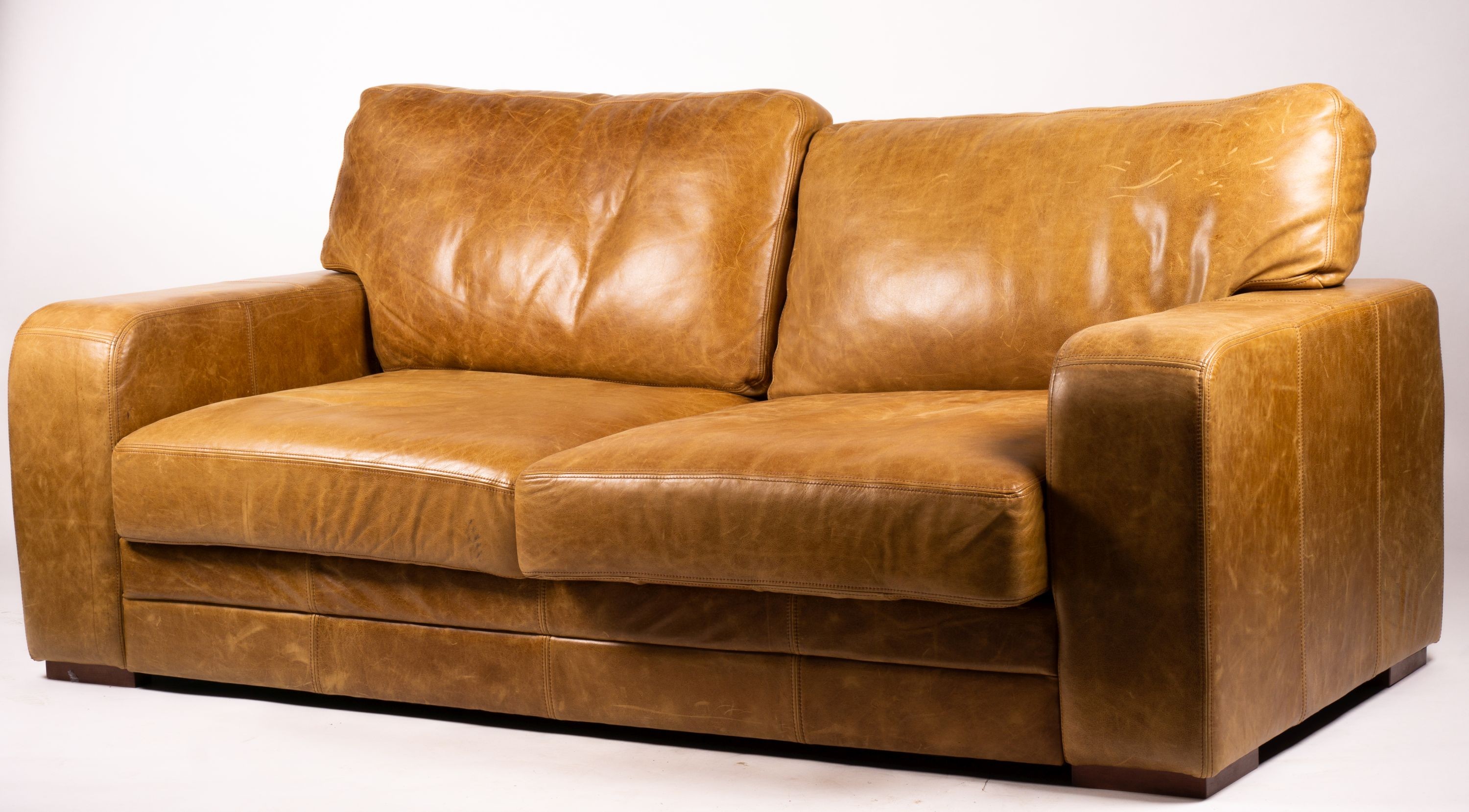 A pair of contemporary tan leather settees, length 200cm, depth 100cm, height 94cm